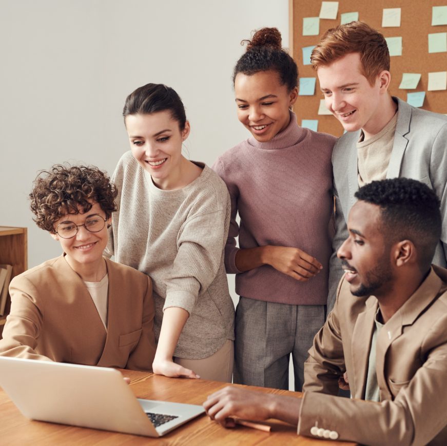 Equipe de jeunes professionnels rassemblés autour d'un ordinateur.