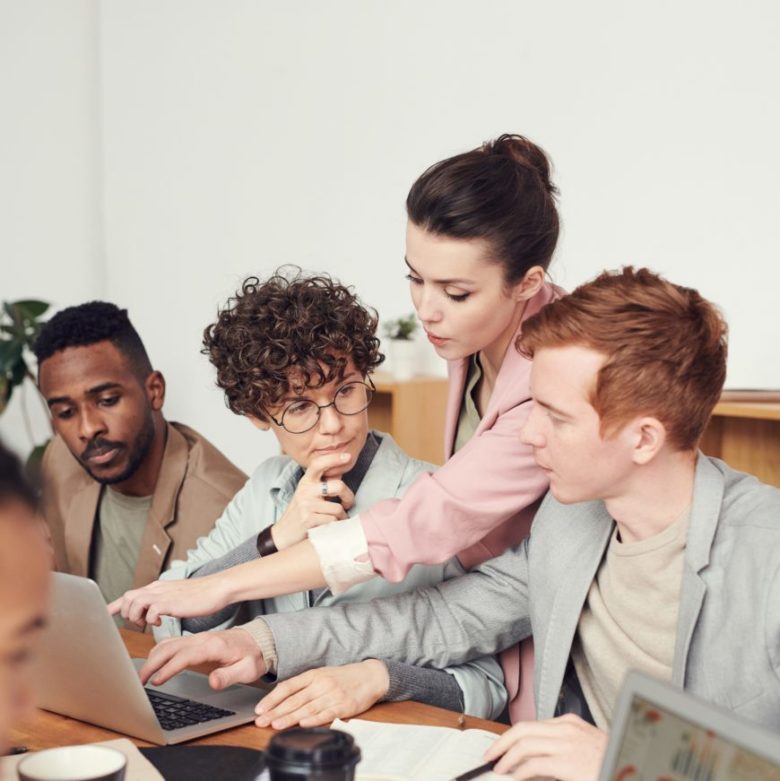 Jeunes professionnels en pleine séance de caoching d'équipe, devant un ordinateur.