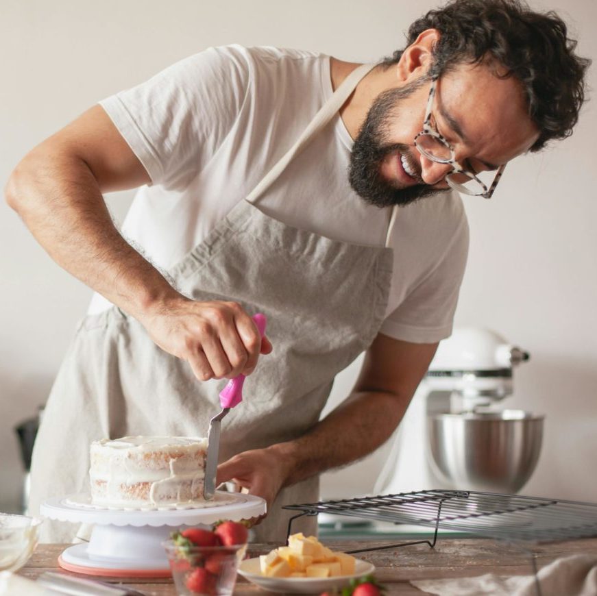Homme cuisinant un gâteau suite à un bilan de compétences réalisé pendant son congé parental.